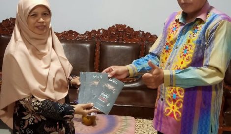 Foto penyerahan donasi buku dari kepala sekolah kepada kepala perpustakaan.