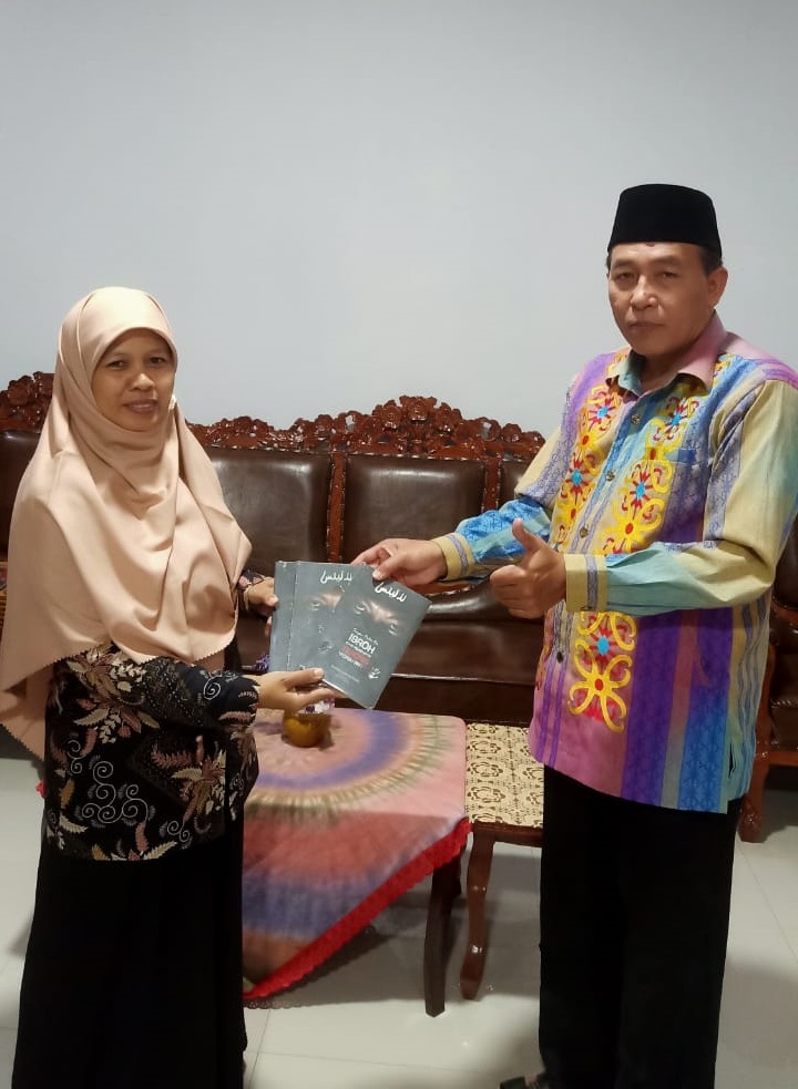 Foto penyerahan donasi buku dari kepala sekolah kepada kepala perpustakaan.